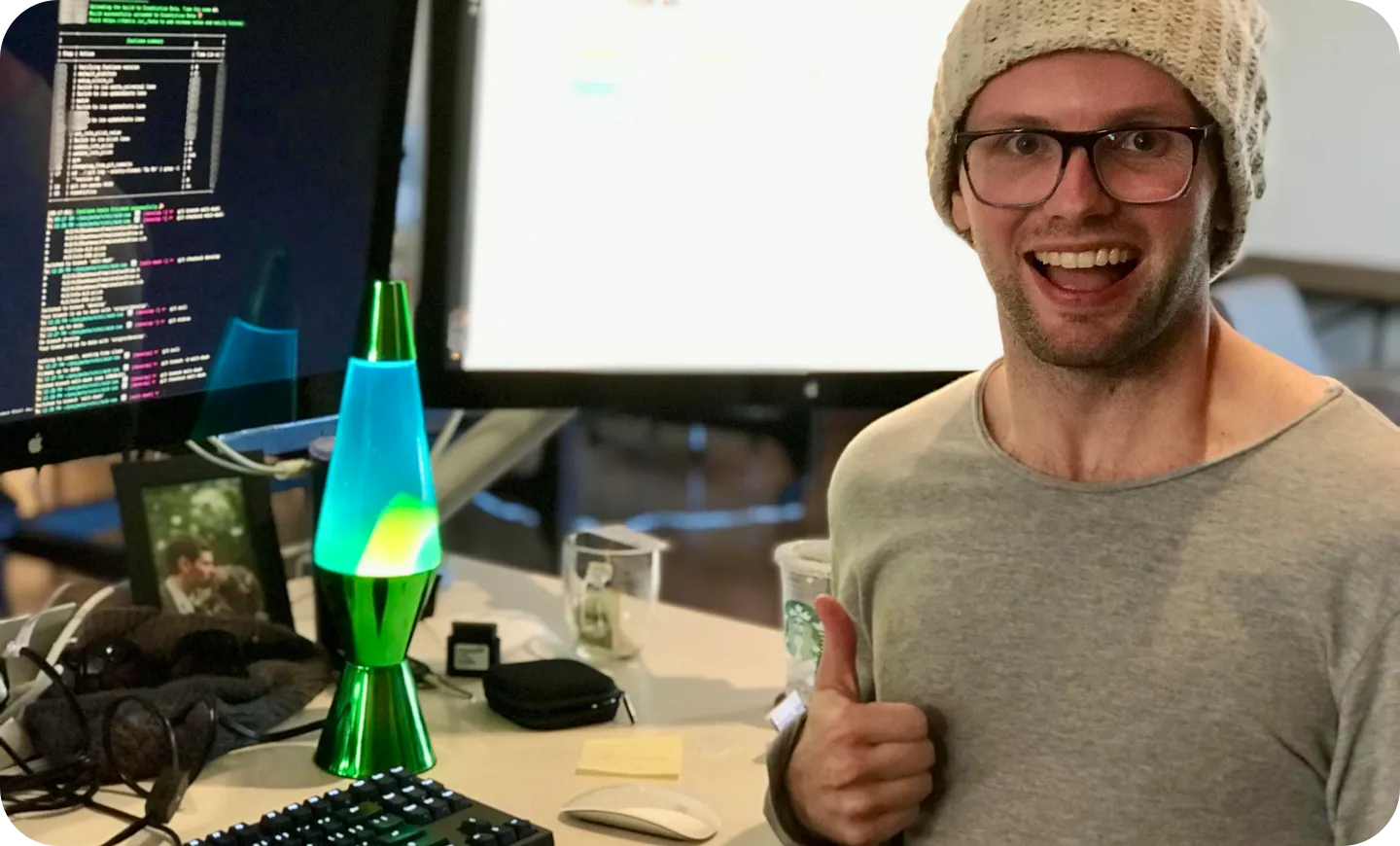 Team member with thumbs up next to a lava lamp